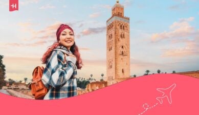 Una giovane donna ammira la splendida moschea Koutoubia a Marrakech, in Marocco