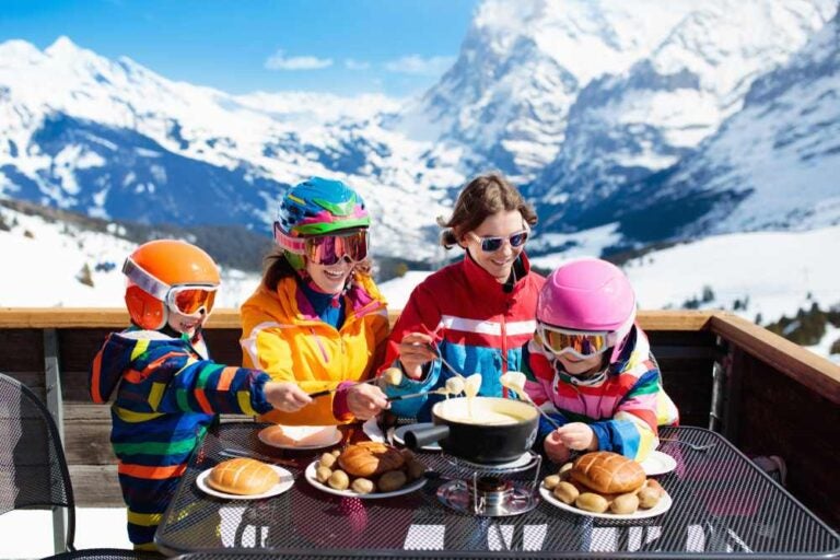 Una famiglia con bambini che si gode un pranzo a base di piatti tradizionali svizzeri.