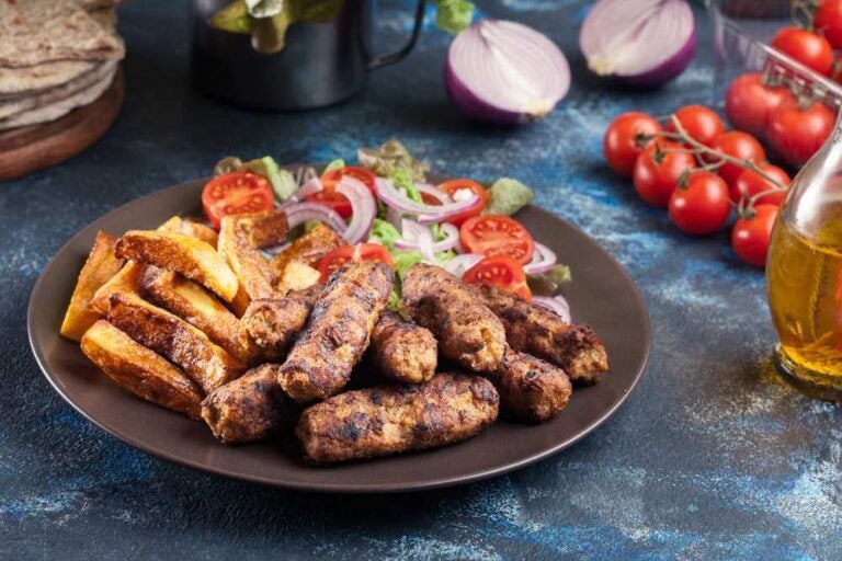 Kebapche or cevapcici, balkan minced meat kebab with french fries and salad.