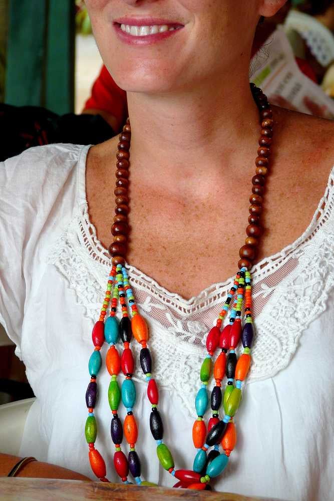 Primo piano di una collana di legno indossata da una giovane donna sorridente a Puerto Viejo, in Costa Rica.