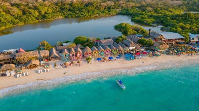 Vista aerea di Playa Blanca, a Barú, con acque cristalline, spiaggia di sabbia bianca, capanne colorate e una vegetazione rigogliosa