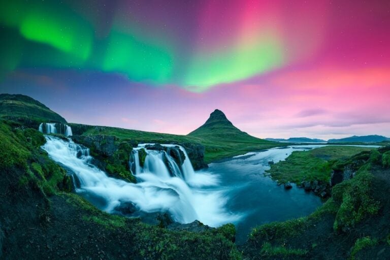 Cielo incredibile con aurore boreali sopra le cascate di Kirkjufellsfoss in Islanda.