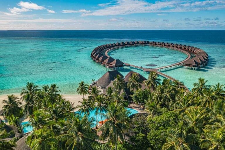 Panorama aereo delle Maldive, ville sull'acqua di una baia con laguna turchese.