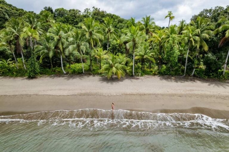 Turista a piedi sulla spiaggia di nuqui, choco, colombia, godendo del paradiso tropicale