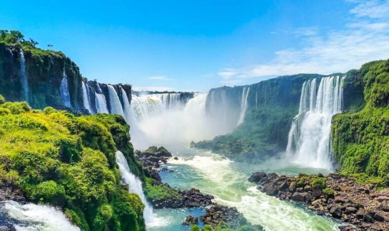 Iguazu,  cascate in natura tropicale vista sulla foresta pluviale con cielo blu e acqua verde