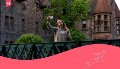 Un turista felice che condivide la sua esperienza sui social media con un selfie