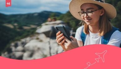 turista con occhiali alla moda e cappello estivo mentre usa il cellulare