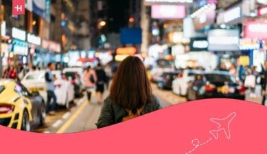 Una giovane viaggiatrice che si reca al mercato di strada di Mongkok di notte a Hong Kong, Cina