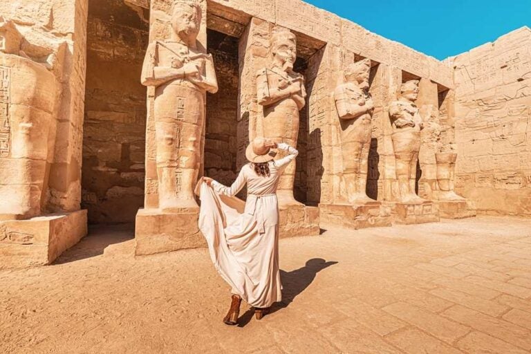 Una ragazza in vacanza, tutta allegra e con indosso un vestito, è appassionata di egittologia e archeologia e vive un'esperienza di viaggio al Tempio di Karnak a Luxor.