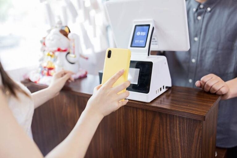 Cassiere che utilizza un dispositivo digitale per il pagamento.