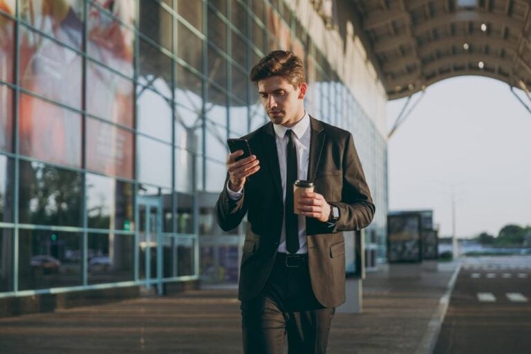 Un uomo che usa uno smartphone mentre viaggia.