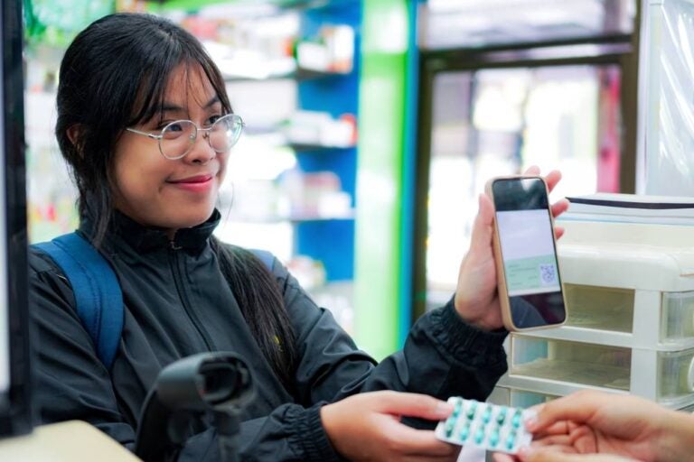 Immagine di un cliente che effettua la scansione per pagare con lo smartphone in Thailandia.