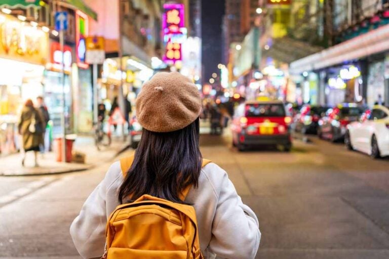 Una giovane turista che passeggia nel mercato notturno di Mong Kok a Hong Kong.