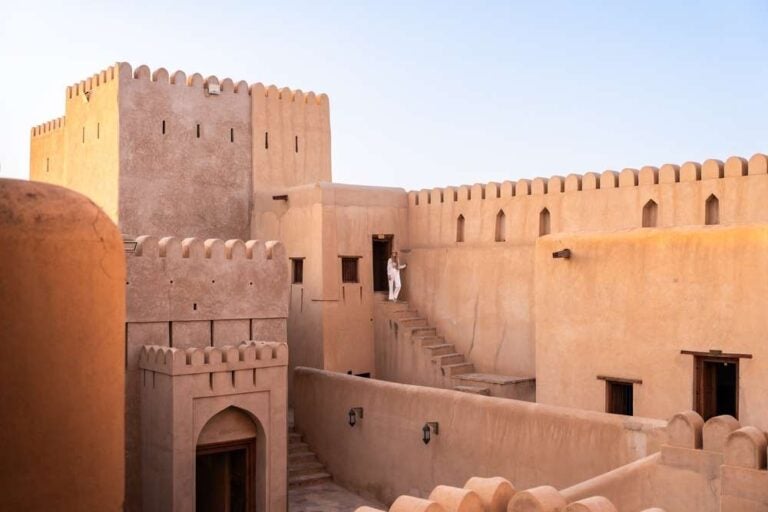 Donna che cammina per i gradini all'interno dello storico fortino di nizwa in Oman