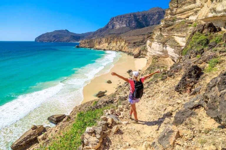 Donna turistica che esplora la spiaggia di Al Fizayah a Salalah