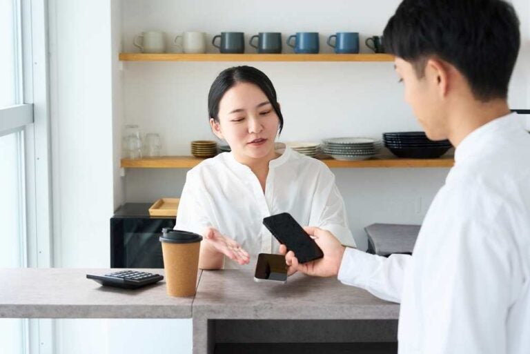 Un uomo paga un caffè con lo smartphone.