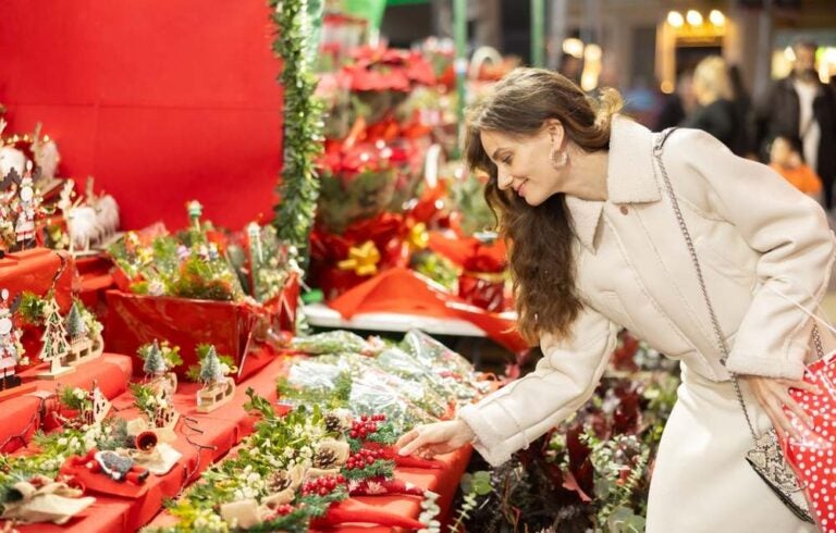 Donna che guarda decorazioni di Natale al mercatino di Roma.