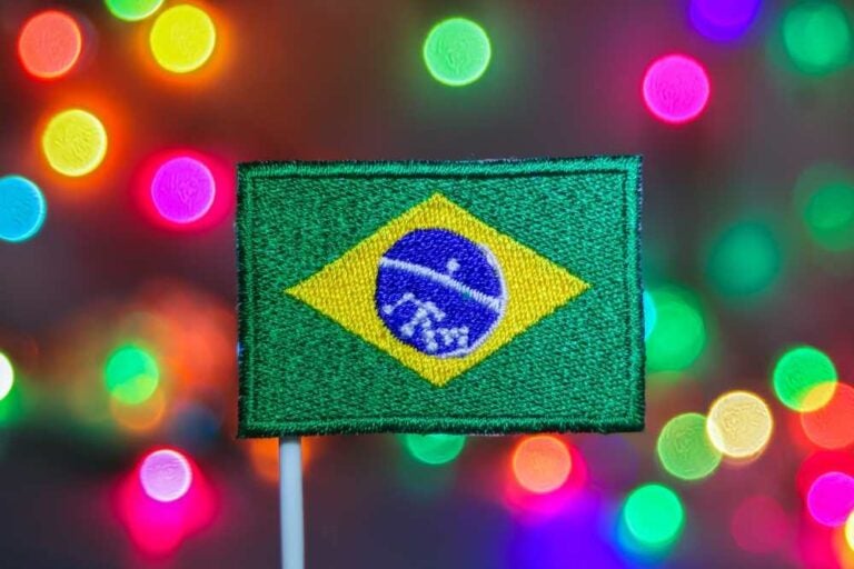 Piccola bandiera brasiliana con luci natalizie di sfondo. 