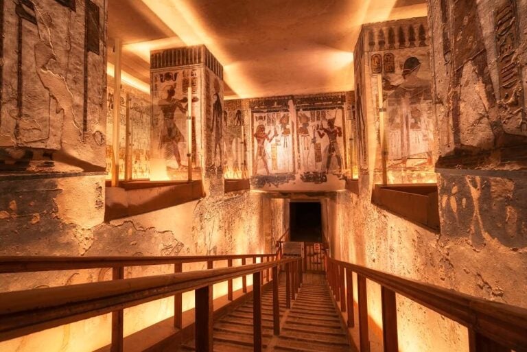 이집트 왕가의 계곡 내부 무덤 벽화와 조명이 비친 내부 계단