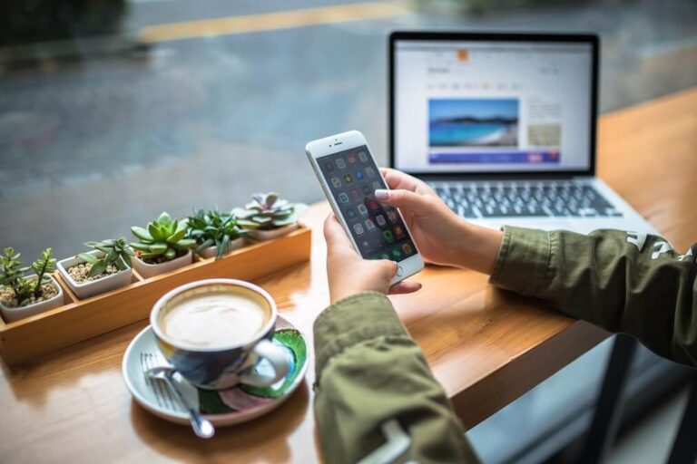 까페에서 노트북과 스마트폰으로 여행 정보를 검색하는 여행자