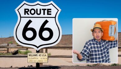 애리조나 윌리엄스의 Route 66 도로 표지판을 배경으로, 캐리어를 어깨에 멘 채 당황한 표정을 짓는 여행자