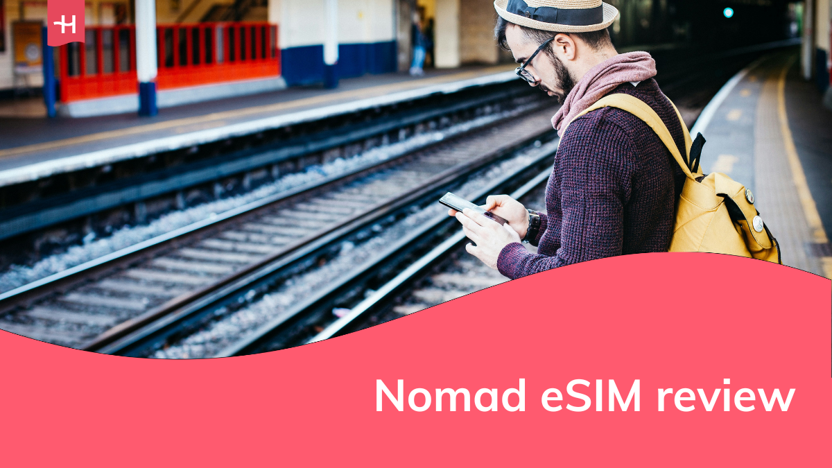 Foto van een man die op zijn smartphone kijkt in een station als uitgelichte afbeelding voor een Nomad eSIM review