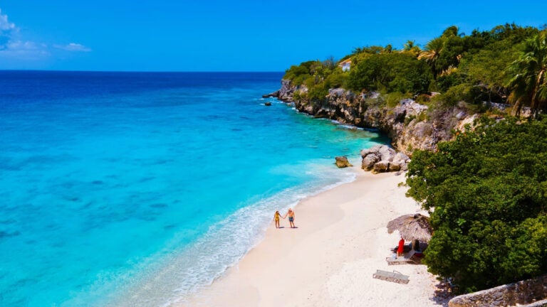 Luchtfoto van een koppel dat een wandeling maakt op Playa Kalki op Curaçao
