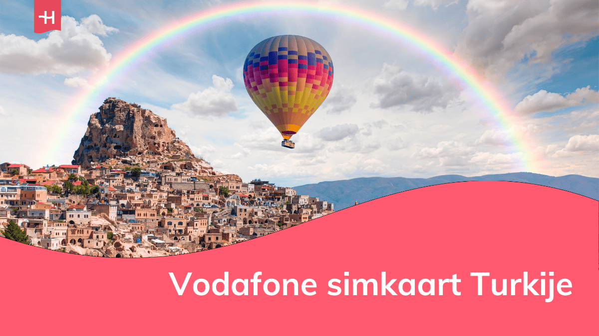 Foto van een luchtballon die over Cappadocië vliegt met een regenboog op de achtergrond als uitgelichte afbeelding voor een pagina over Vodafone simkaart voor Turkije