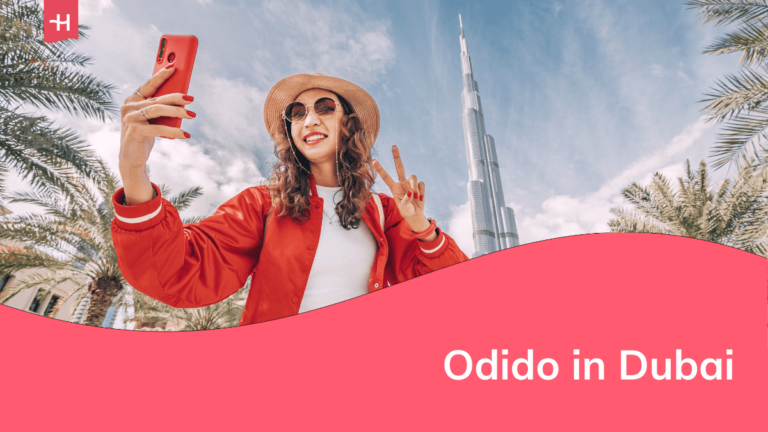 Foto van een vrouw die een selfie neemt voor de Burj Khalifa in Dubai als uitgelichte afbeelding voor een artikel over Odido in Dubai