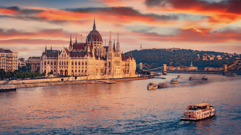 Sfeerbeeld van Boedapest: een boot op de Donau met het Parlementsgebouw op de achtergrond