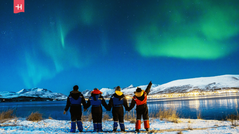 Foto van een groep toeristen dat het noorderlicht bewondert in Tromsø