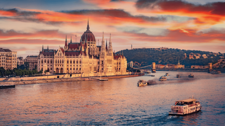 Sfeerbeeld van Boedapest: een boot op de Donau met het Parlementsgebouw op de achtergrond