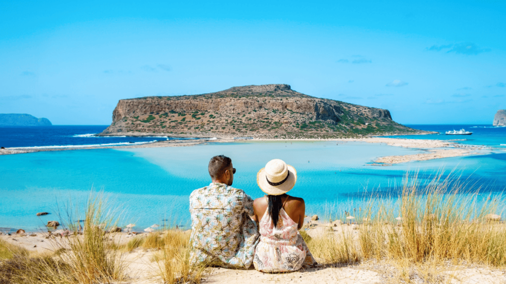 Foto van een koppel dat uitkijkt over de azuurblauwe zee op Kreta, een top vakantiebestemming in november
