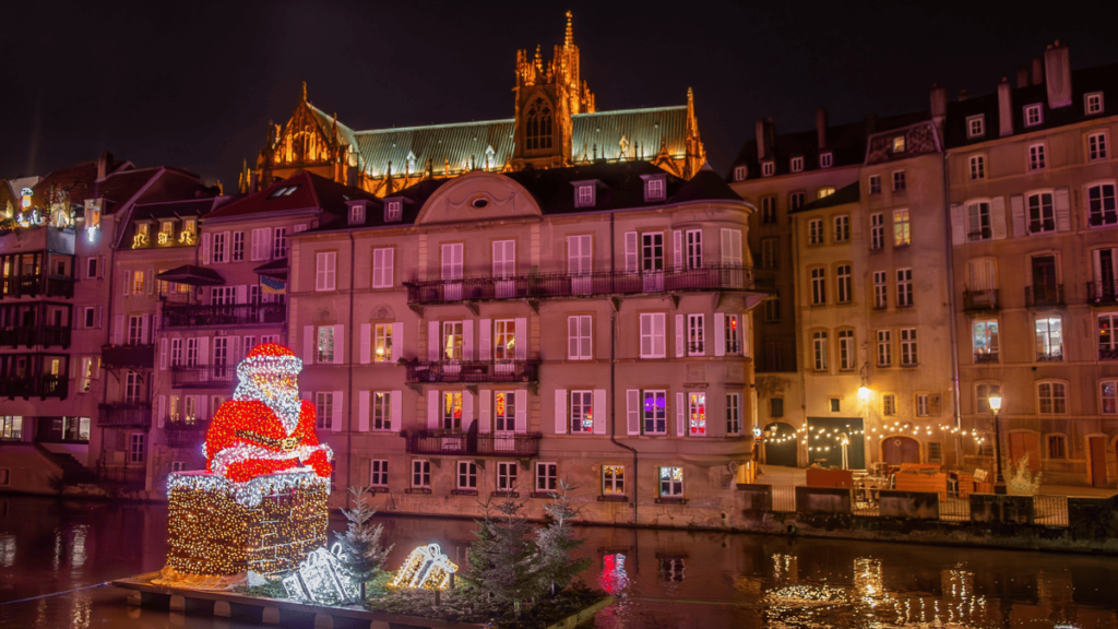 Sfeerbeeld van de kerstmarkt van Metz met een grote opblaasbare kerstman op de rivier