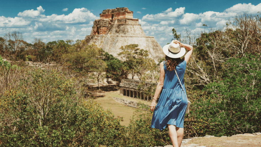 Foto van een vrouw die de ruïnestad Uxmal bewondert