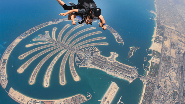 Foto van een parachutespringer boven Palm Jumeirah, in Dubai