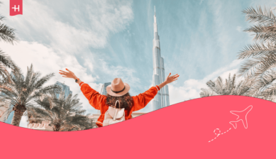 Jonge vrouw poseert met haar armen open voor de Burj Khalifa