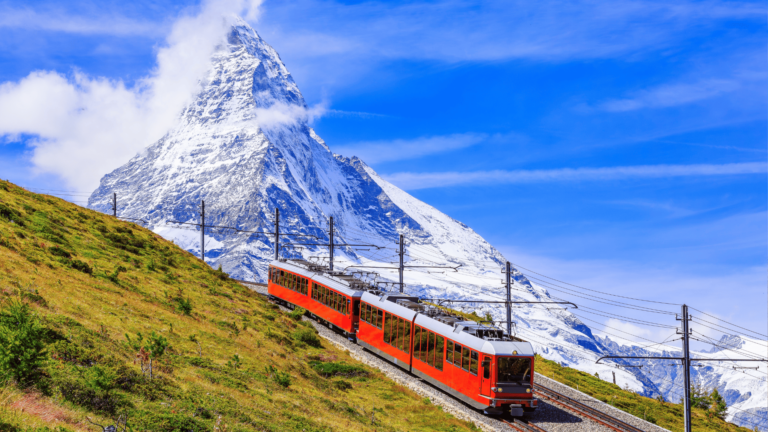 Foto van een rode trein in de voorgrond en de Matterhorn op de achtergrond