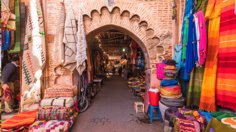 Foto van een steegje in de Medina van Marrakech waarin een markt wordt gehouden