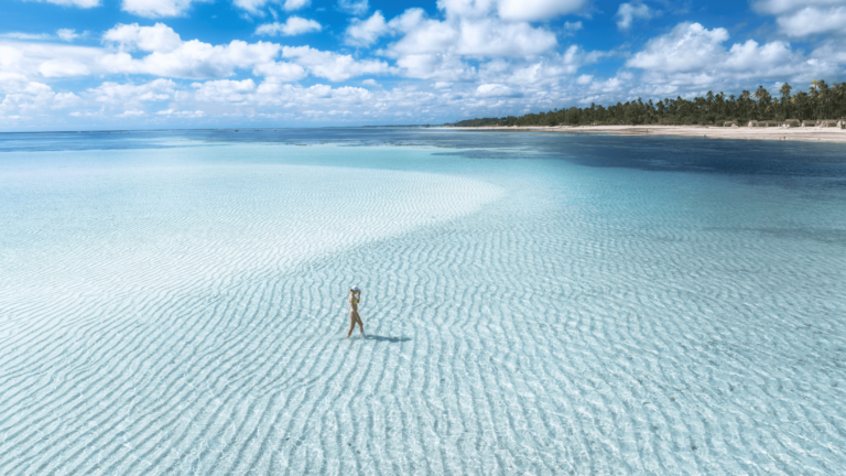 Foto van een vrouw in ondiep water op een strand op Zanzibar