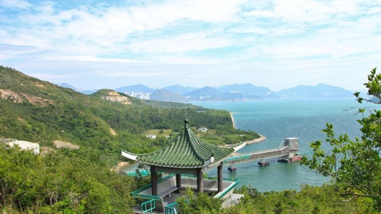 Een traditioneel Chinees paviljoen met een groen dak op een groene heuvel op Lamma Island, uitkijkend over de Zuid-Chinese Zee.