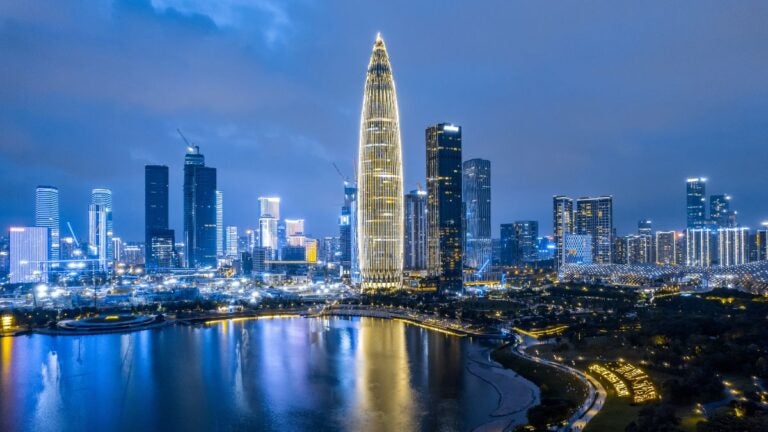 Een prachtig nachtzicht op de skyline van Shenzhen vanaf Talent Park, met de verlichte "Spring Bamboo" China Resources Tower en kleurrijke reflecties op het meer.