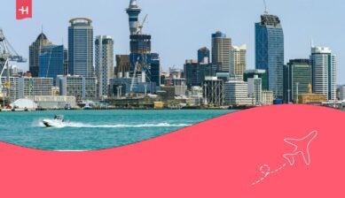 De moderne skyline van Auckland, Nieuw-Zeeland, gezien vanaf het water met een speedboot in de voorgrond.