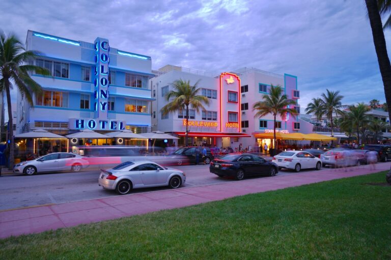 Art-decogebouwen en neonverlichting langs Ocean Drive in Miami Beach bij zonsondergang.