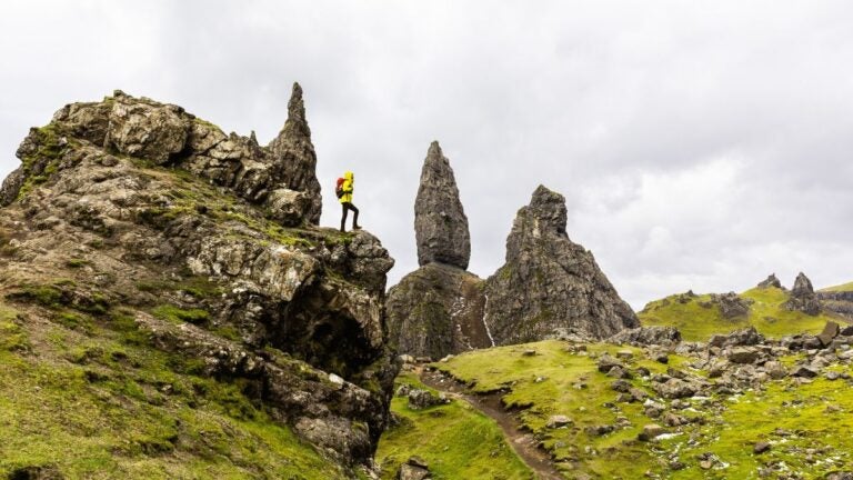 Een ervaren wandelaar op een uitdagende rotsformatie in de Schotse Hooglanden.