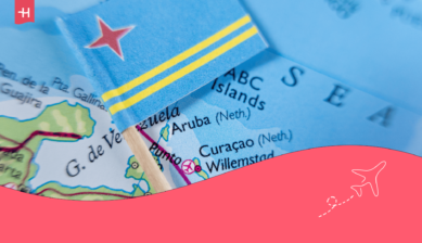 De vlag van Aruba op een prikkertje met op de achtergrond een wereldkaart ingezoomd op Aruba als uitgelichte afbeelding voor een artikel over internet op Aruba