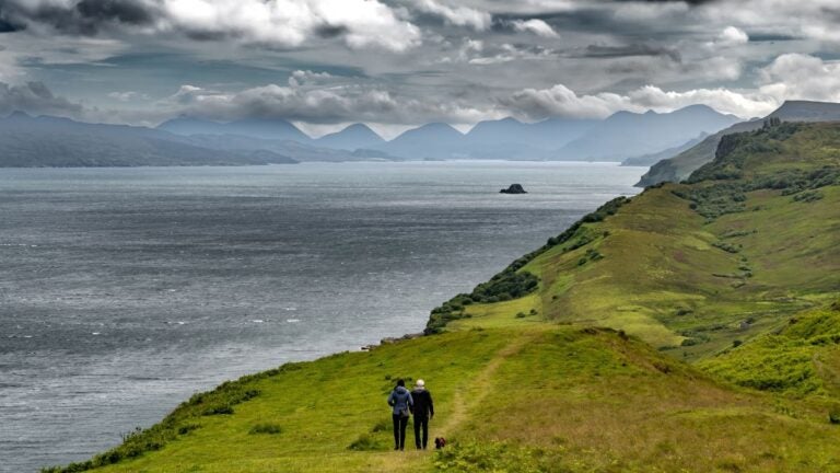Wandelen in Schotland voor beginners: een koppel met hun hond op een kustpad.