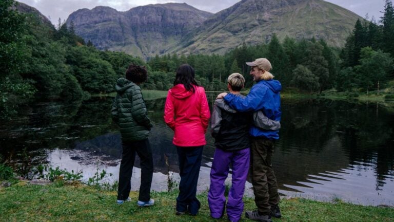Een familie geniet van een wandeling in Schotland langs een prachtig meer.