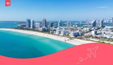 Luchtfoto van Miami Beach met hoge hotels en appartementen langs de kust en de turquoise oceaan.