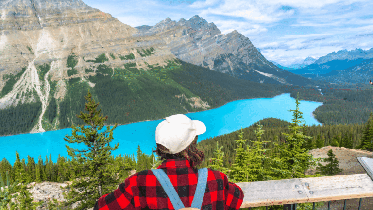 Vrouw bewondert het turquoise water van Lake Payto in Banff National Park